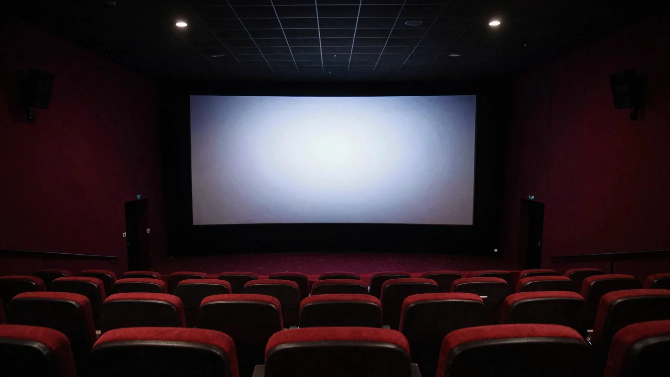 Dim cinema auditorium with a single lit screen, dramatic low-key